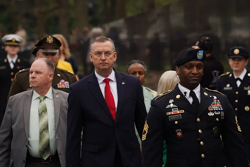 Secretary of Veterans Affairs Doug Collins walks with uniformed service members at the Vietnam Veterans Memorial in Washington